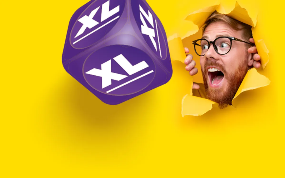 Vrolijke man kijkt verrast en enthousiast naar een grote paarse XL dobbelsteen op een gele achtergrond.